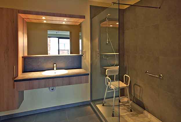 Uitgeruste badkamer met wastafel en douche in een assistentiewoning van Numa & Maria